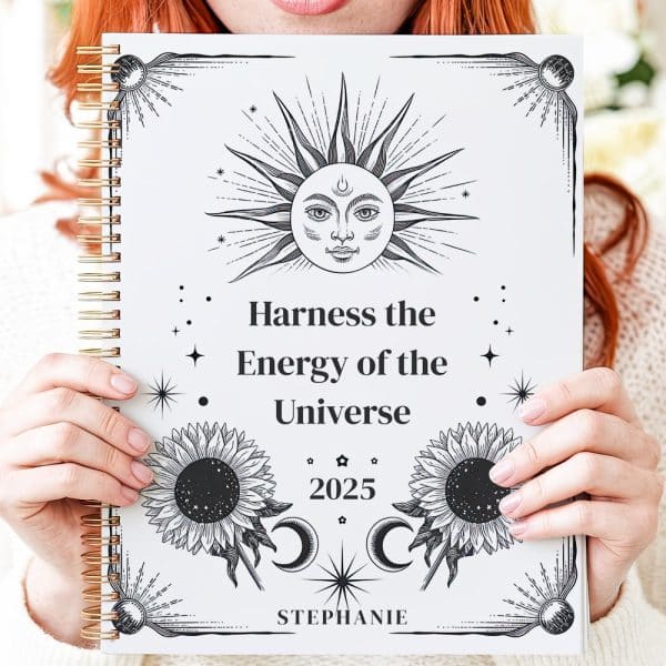 Hands Hold A 2025 Planner Featuring A Celestial Sun Design And The Words Harness The Energy Of The Universe.