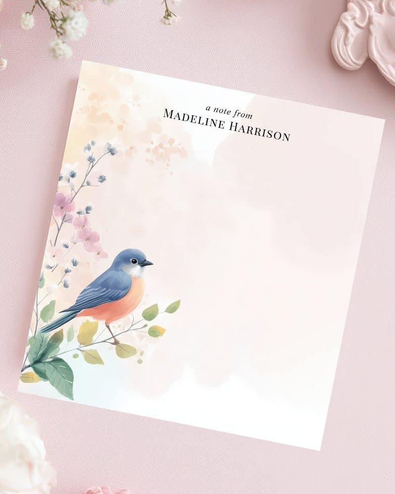 Stationery featuring a blue bird perched on a flowering branch.