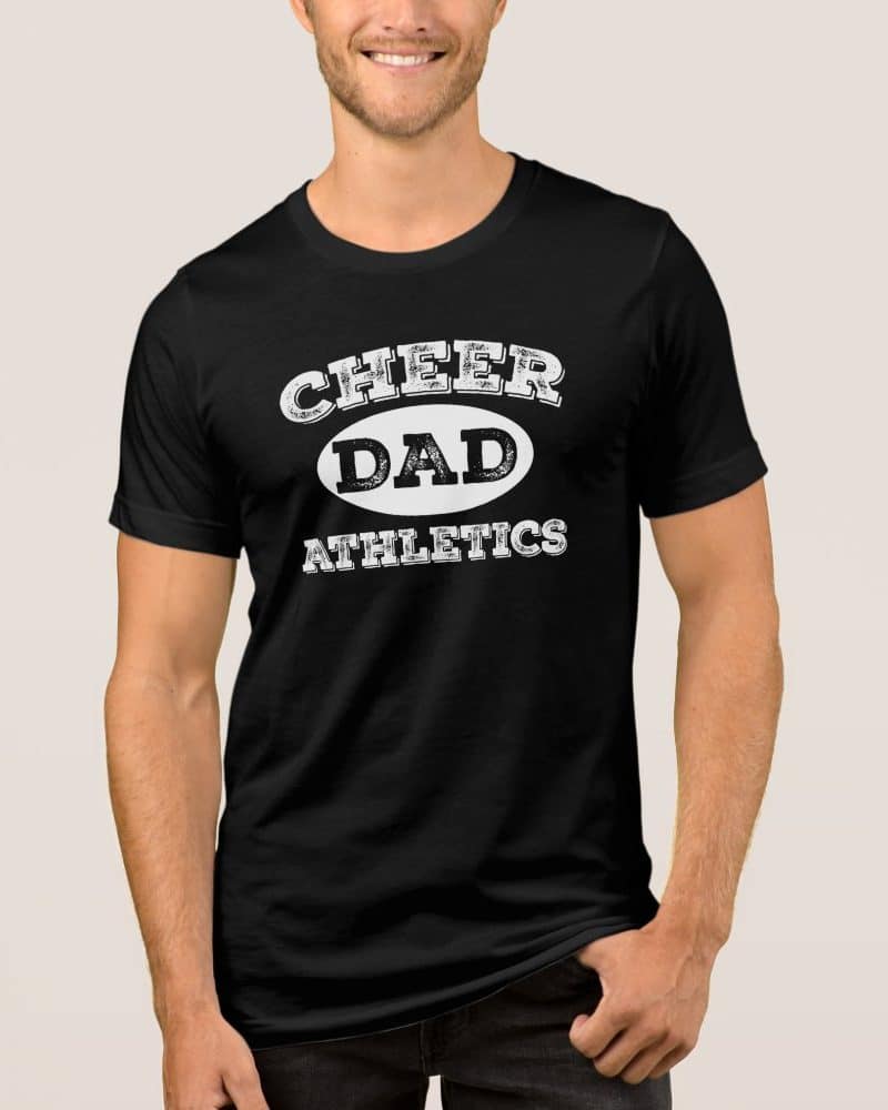 Man wearing a black t-shirt that says Cheer Dad Athletics in a distressed white print.