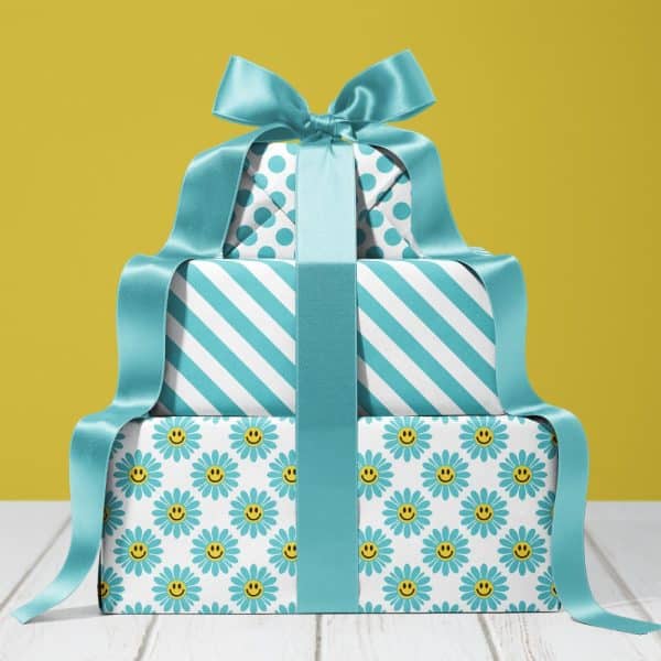 Stack Of Three Gifts Wrapped In Teal And White Paper, Tied With A Large Teal Ribbon. The Bottom Gift Features A Daisy Pattern With Smiley Faces.