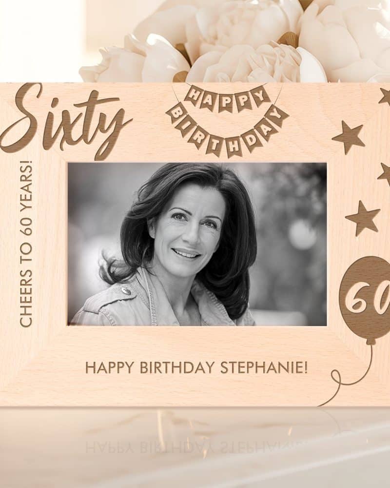 Light wood 60th birthday photo frame with a black and white photo of a woman, the number sixty, and the words Happy Birthday.