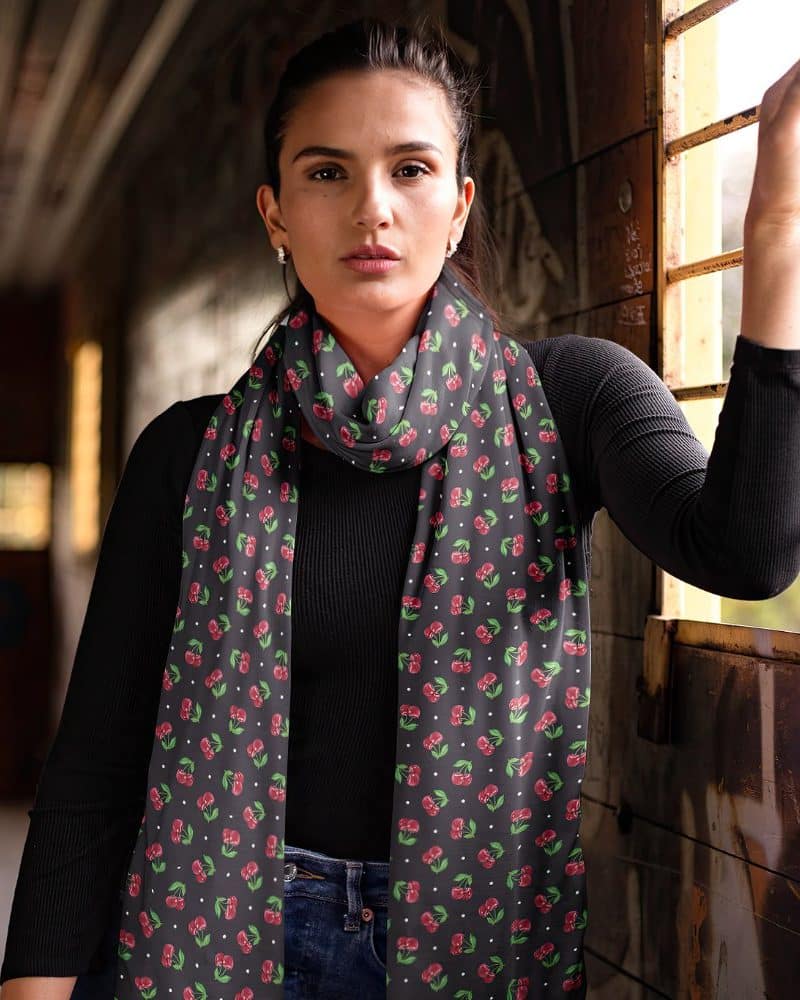 Woman wearing a black cherry-print scarf.