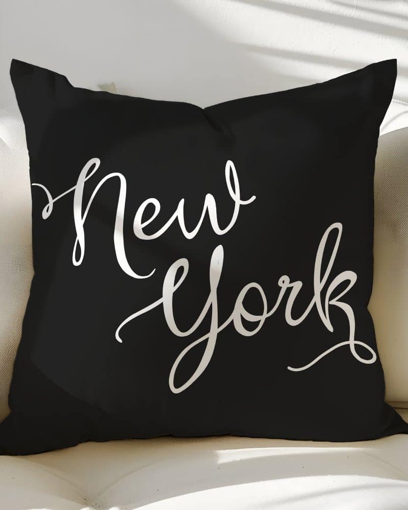 Black throw pillow with the words New York in a white, stylized script font.
