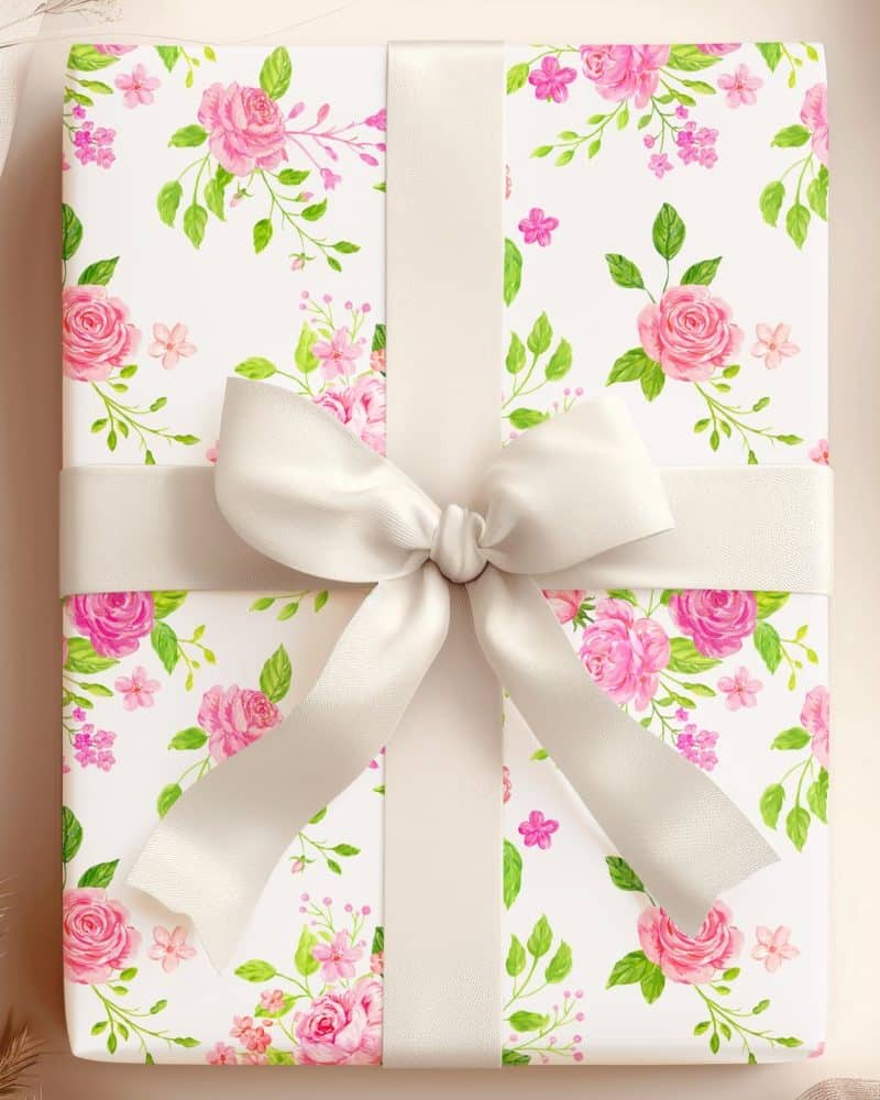 Gift wrapped in pink rose floral paper with a cream-colored ribbon.
