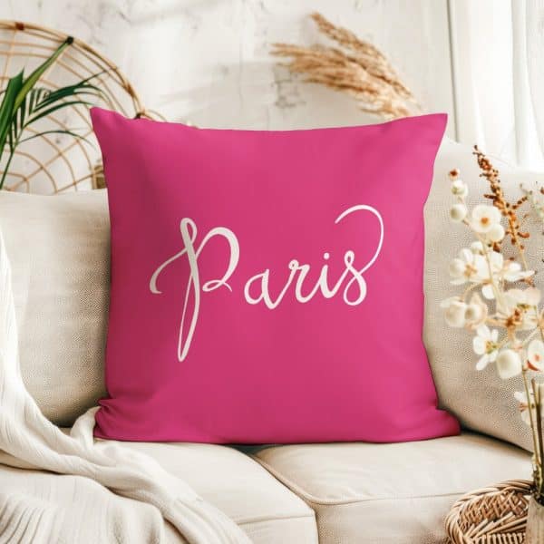 Pink Square Pillow With The Word Paris In White Script.