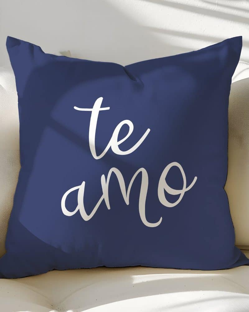 Navy blue throw pillow with the words te amo in white script.