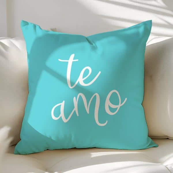 Teal Pillow With The Words Te Amo In White Script.
