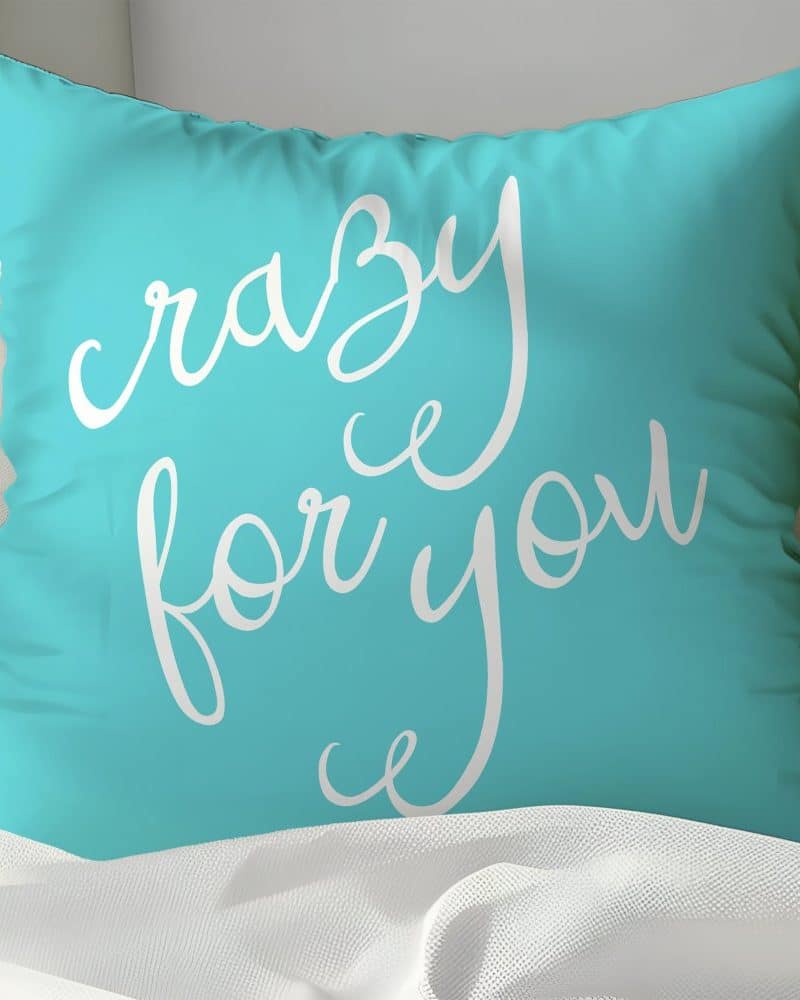 Teal pillow with the words Crazy for You in white script.