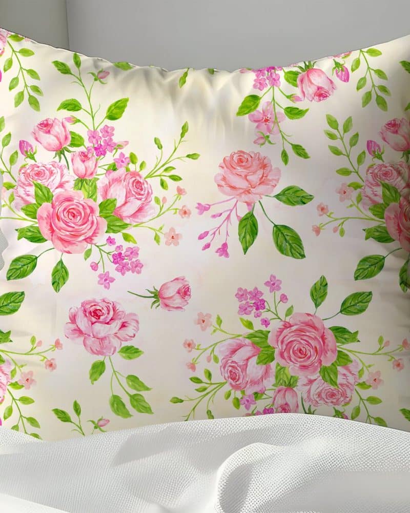 Cream pillow with a pink rose floral pattern.