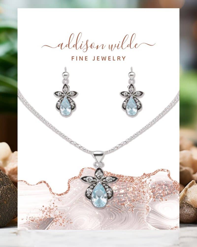 Silver necklace and earrings set featuring light blue teardrop gemstones and flower accents.