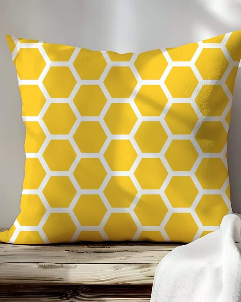 Yellow square pillow with a honeycomb pattern.