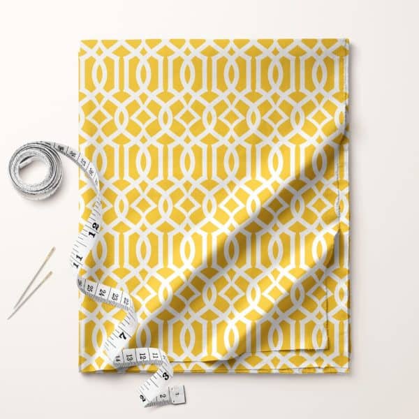Mustard Yellow Fabric With A White Geometric Pattern, Accompanied By A Measuring Tape And Needles.