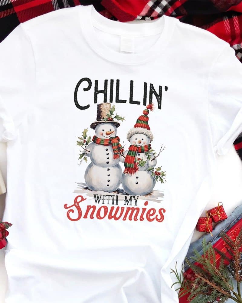 White t-shirt with a Christmas design featuring two snowmen and the text Chillin' with my snowmies.
