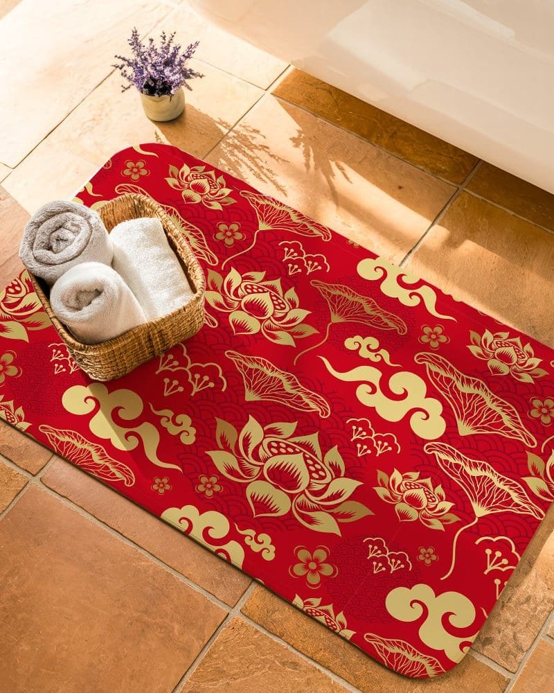 Red bath mat with gold lotus flower and cloud pattern.