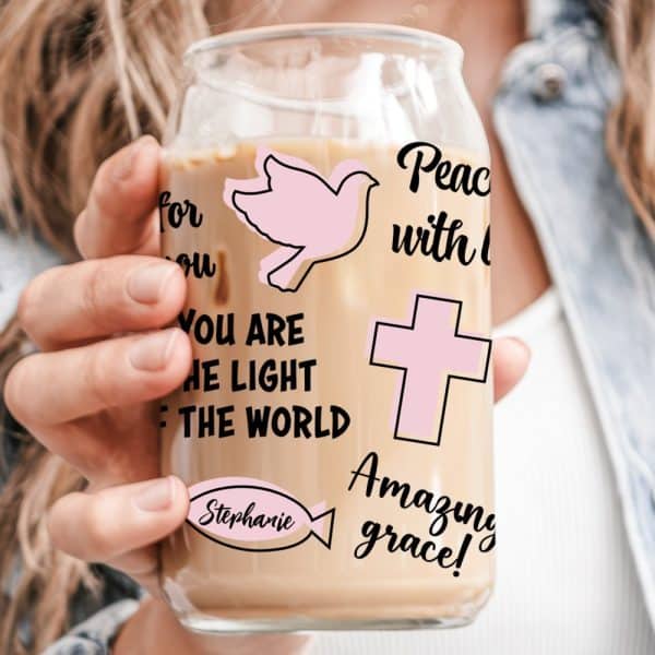 A Person Holds A Glass Iced Coffee Tumbler With Religious-Themed Graphics And The Name Stephanie.
