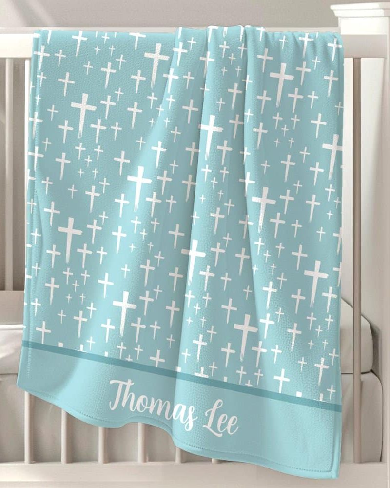 Light blue baby blanket with a white cross pattern and the name Thomas Lee.