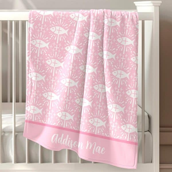 Pink Baby Blanket With A Repeating Pattern Of White Stylized Fish And Crosses, Personalized With The Name Addison Mae.
