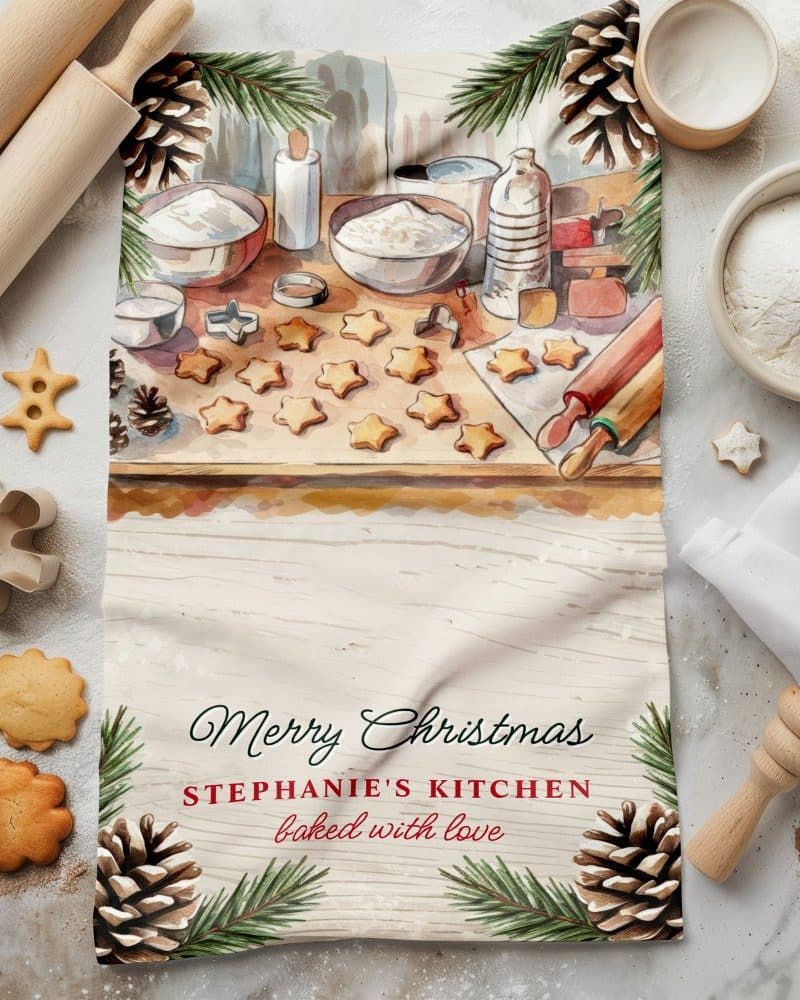 Christmas tea towel featuring a watercolor illustration of star-shaped cookies being baked.
