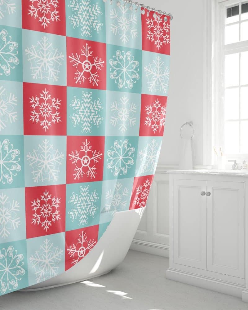 A shower curtain with a repeating pattern of white snowflakes on a teal and coral checkered background.