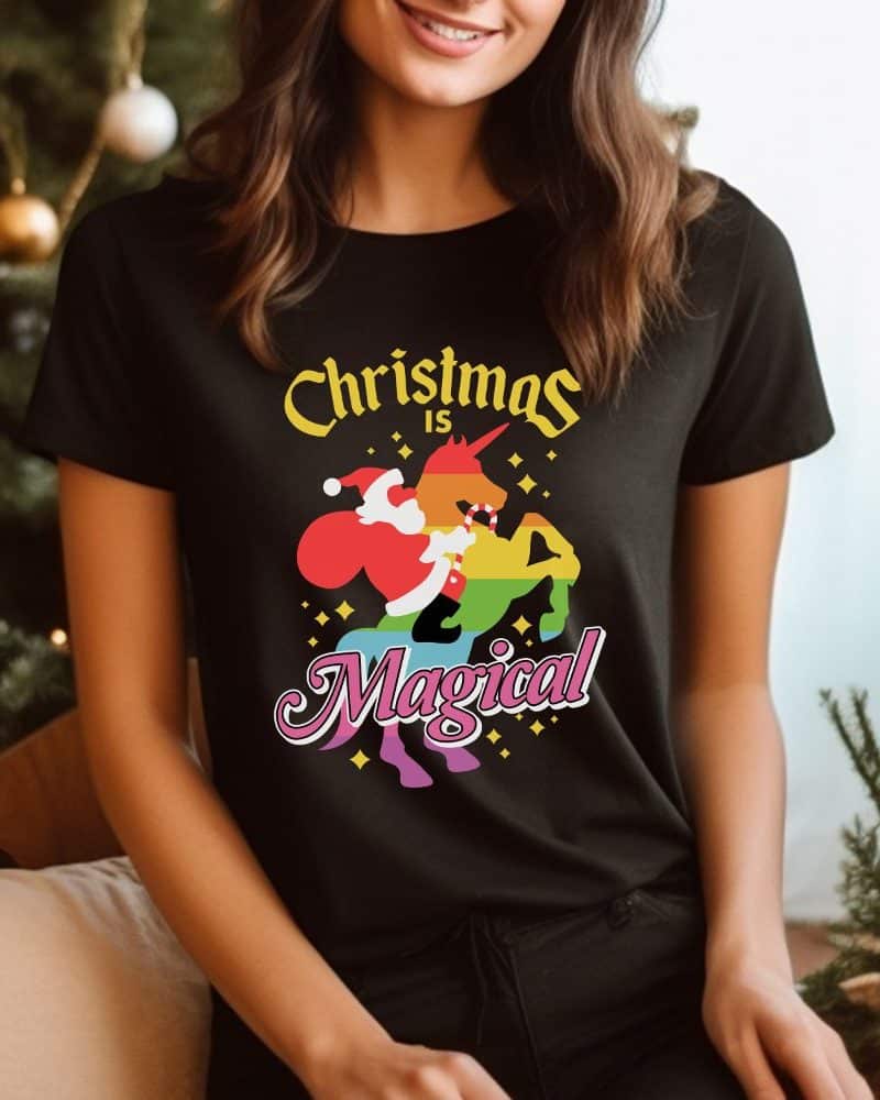 Woman wearing a black t-shirt with a rainbow unicorn and Santa Claus design. The text reads Christmas is Magical.