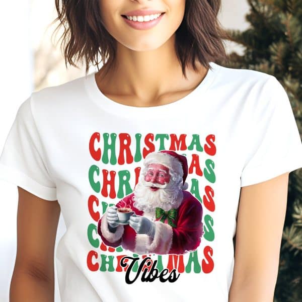 White T-Shirt Featuring Santa Claus Enjoying A Warm Drink, Surrounded By The Repeated Words Christmas Vibes In Retro Colors.