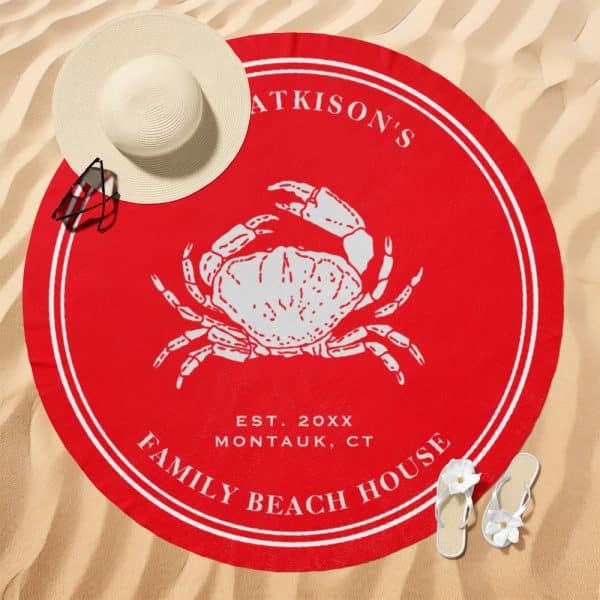 Red Round Beach Towel With A White Crab Illustration In The Center, Surrounded By Family Name And Beach House Details.