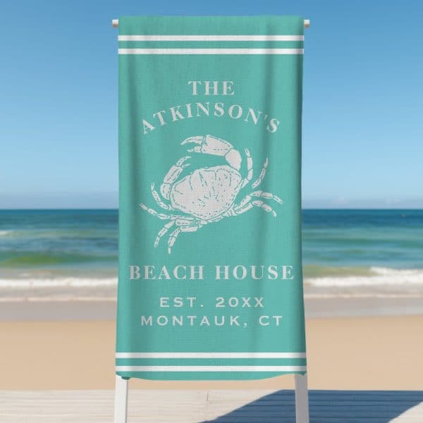 Teal Beach Towel With A Crab Illustration And The Atkinsons Beach House Text.