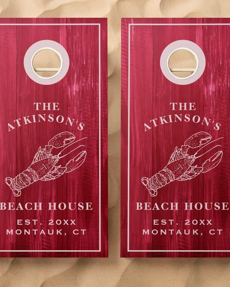 Two red wooden cornhole boards with a lobster illustration, "The Atkinsons Beach House Est. 20xx Montauk, CT" text.