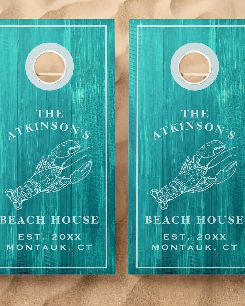 Two teal cornhole boards with a lobster and "The Atkinsons' Beach House, Est. 20XX Montauk, CT" design.