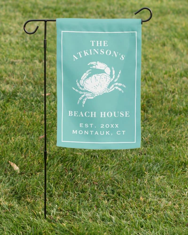 Teal beach house yard sign with a crab illustration, The Atkinsons family name, and Montauk, CT location.