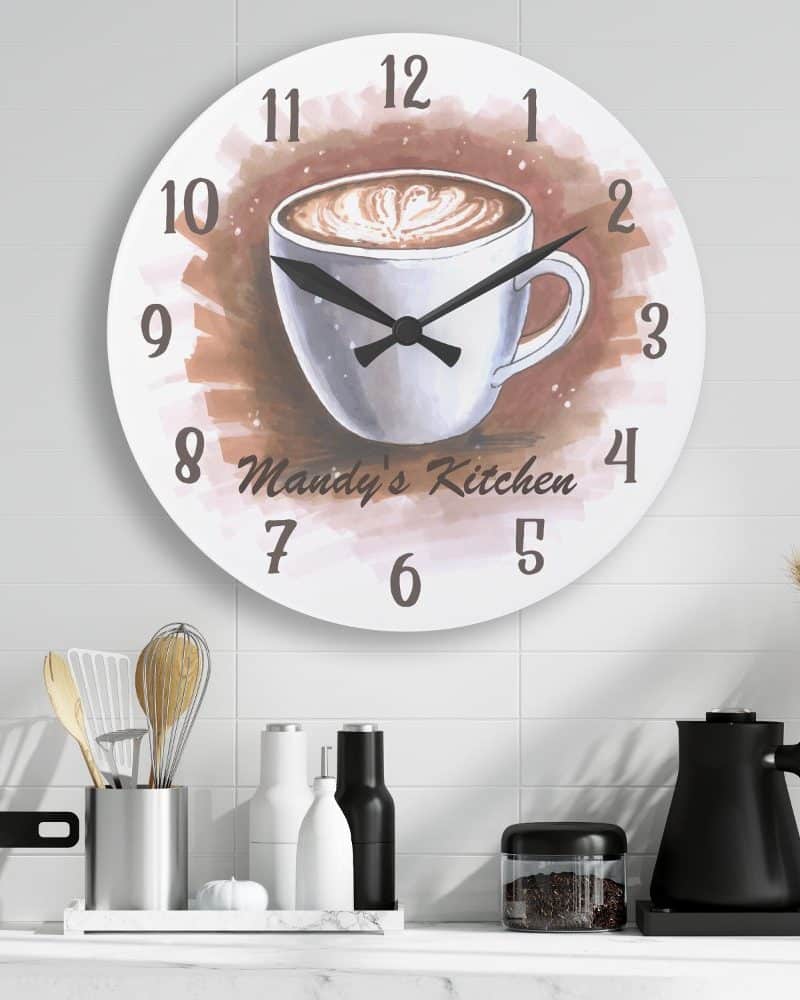 Round kitchen clock featuring a watercolor illustration of a coffee mug; Mandy's Kitchen is inscribed below the mug.