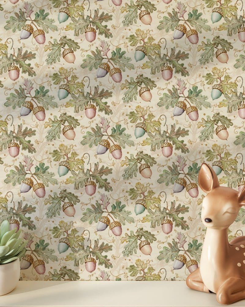 A fawn figurine rests in front of wallpaper featuring a repeating pattern of acorns and oak leaves in muted greens, pinks, and golds on a cream background.