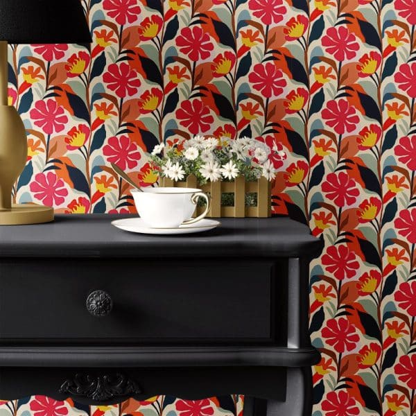 Black Nightstand With A Teacup And Saucer, In Front Of A Bold Floral Wallpaper.