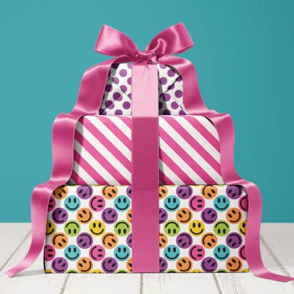 A Stack Of Three Presents Tied With A Large Pink Ribbon. The Top Present Has Purple Polka Dots, The Middle Has Pink Stripes, And The Bottom Has Colorful Smiley Faces.