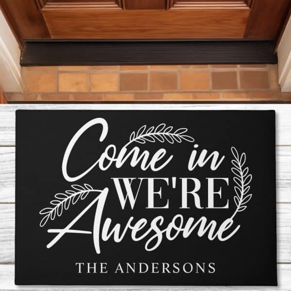 Black Welcome Mat With White Lettering That Says Come In We'Re Awesome, And The Andersons At The Bottom.