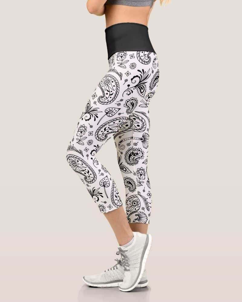 A woman's leg wearing white capri leggings with a black paisley pattern.