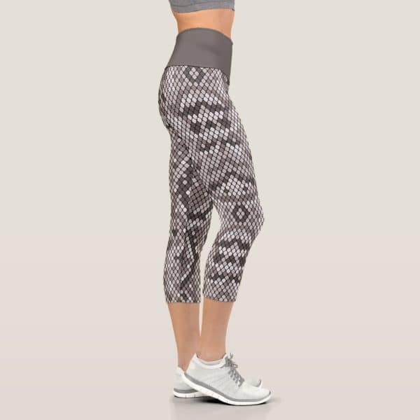 Woman'S Legs In Snakeskin Print Cropped Leggings And White Athletic Shoes.