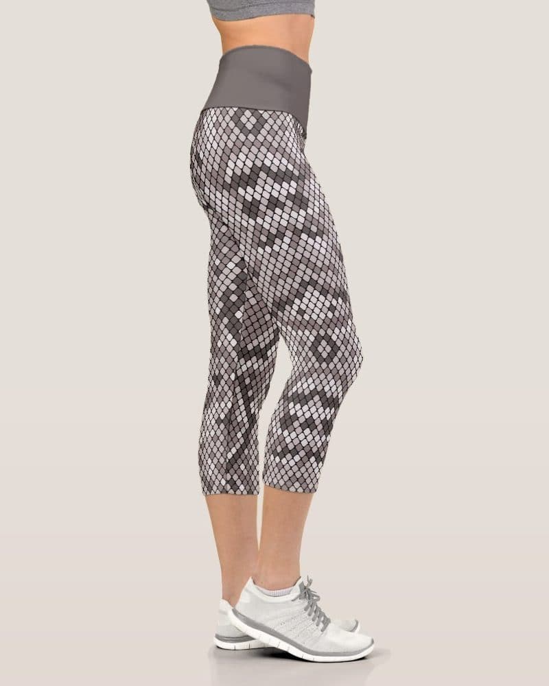 Woman's legs in snakeskin print cropped leggings and white athletic shoes.