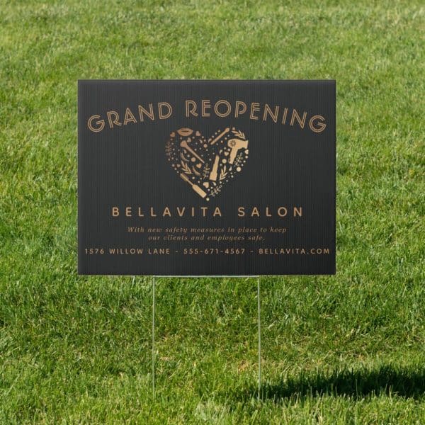 Black Grand Reopening Sign For Bella Vita Salon. A Gold Heart With Salon Tools Is Featured.
