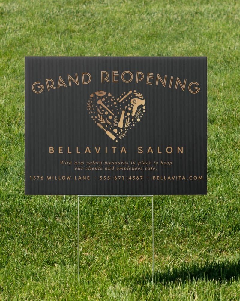 Black grand reopening sign for Bella Vita Salon. A gold heart with salon tools is featured.