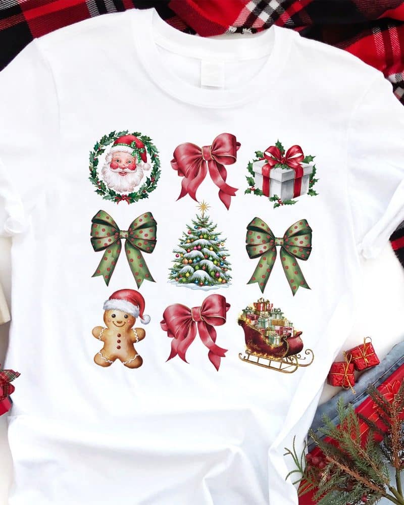 White t-shirt with a repeated pattern of festive Christmas images including bows, Santa, a Christmas tree, a gingerbread man, and a sleigh.