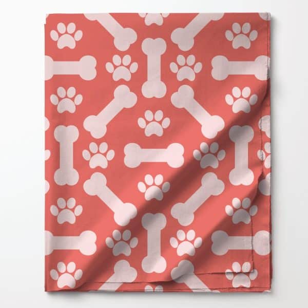 Coral Fabric With A Repeating Pattern Of White Bones And Paw Prints.