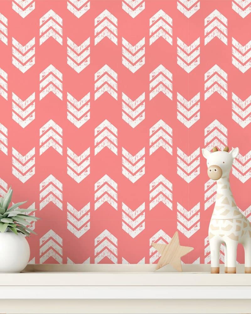 Coral wall with a white chevron pattern, featuring a small giraffe toy and a succulent plant on a shelf.