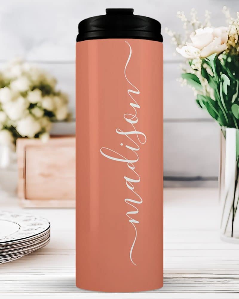 Coral-colored travel tumbler with the name Madison in white script.