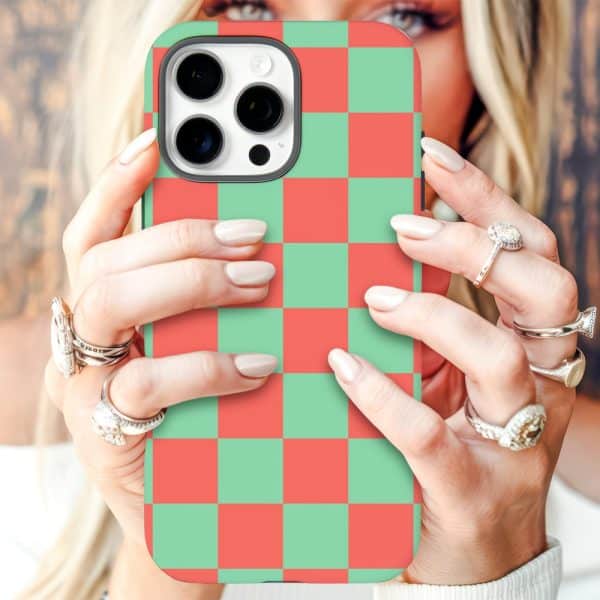 Close-Up Of Hands Holding A Phone With A Red And Green Checkered Phone Case.