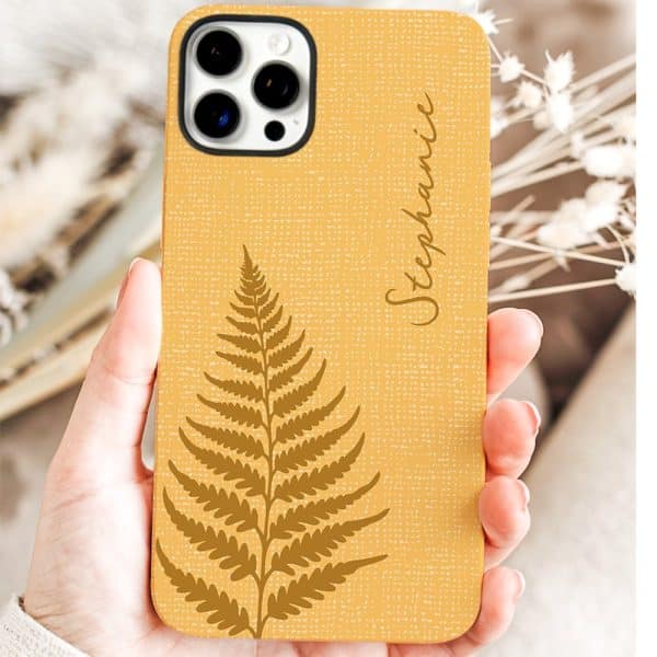 A Mustard Yellow Phone Case With A Gold Fern Design And The Name Stephanie.