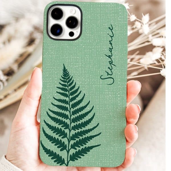 A Hand Holds A Sage Green Phone Case Featuring A Dark Green Fern And The Name Stephanie.