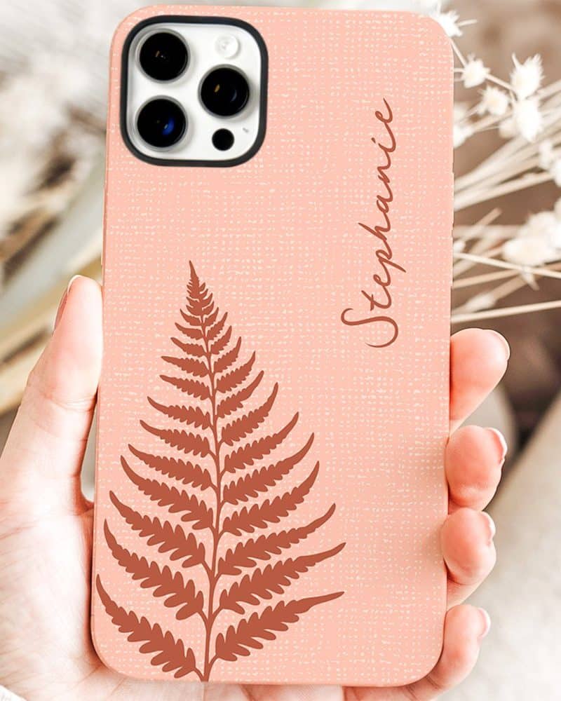 A peach-colored phone case with a brown fern design and the name Stephanie.