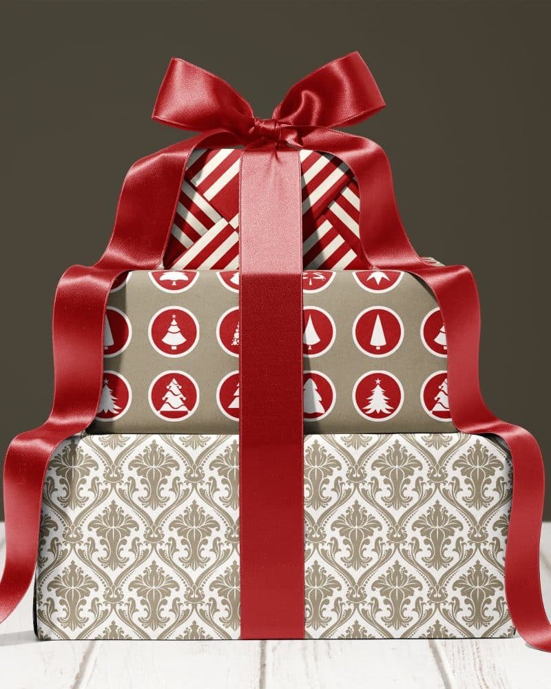 Stack of three Christmas presents tied with a large red ribbon.