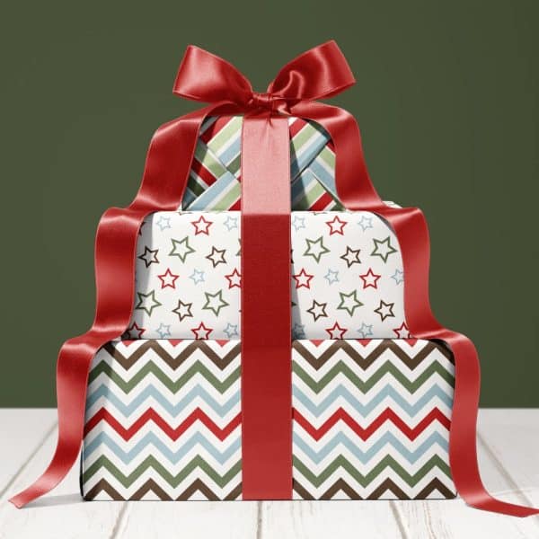 Stack Of Three Festively Wrapped Presents With A Large Red Ribbon.